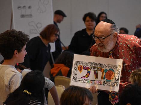 man holding a sign with Hebrew letters on it, showing it to children