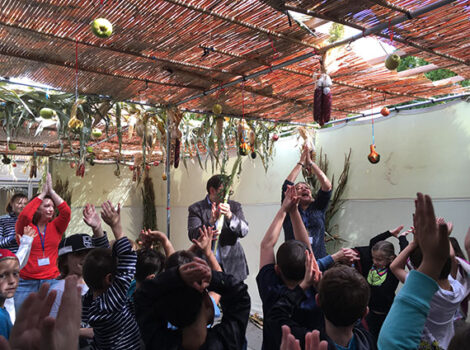 group of people having fun in a sukkah