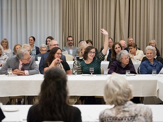 Woman raises hands at 12 Jewish Questions class