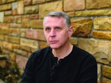 Dr. Jacques Berlinerblau in black crewneck in front of stone wall