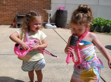 two young girls play outside