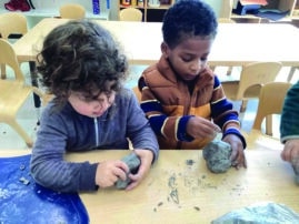 Two toddlers work with clay