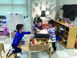 three young children doing shadow play in the classroom