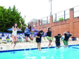 5 children jump into a swimming pool.