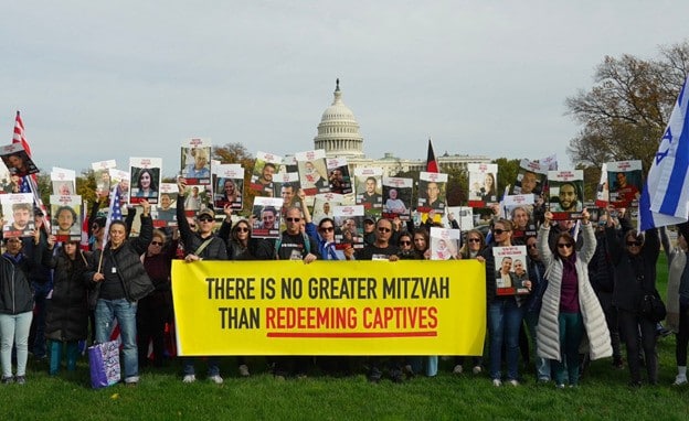 Marchers on National Mall holding sign "There is no greater mitzvah than redeeming captives"