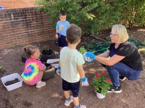 Teacher works in the garden with three young children